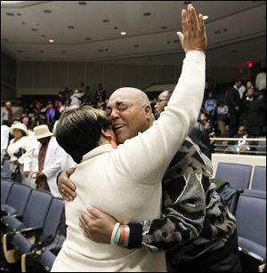 Faye Lyons, left, and Brian Williams hug during a service of St. Mark Baptist Church.