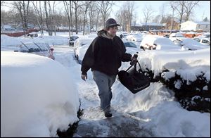 Bambino’s Pizza employee Mike Broadbent battles the cold to deliver a pizza to a customer Monday. Deliveries were restricted to the immediate Toledo area.