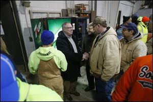 Toledo Mayor D. Michael Collins, left, shakes hands with Bob Sadowski, right, as other employees of  The Division of Streets, Bridges & Harbor surround him at the headquarters on West Central Avenue today.