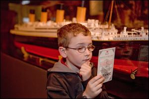 A youngster inspects a program about the  Titanic: The Artifact Exhibition coming to the Imagination Station in February.