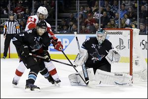 San Jose Sharks goalie Antti Niemi (31) stops a shot on goal next to teammate Brad Stuart (7) and Detroit Red Wings' Todd Bertuzzi (44) during the second period in San Jose.