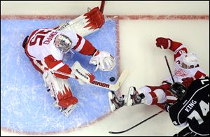 Detroit Red Wings goalie Jimmy Howard, right, stops a shot by Los Angeles Kings left wing Dwight King on Saturday in Los Angeles.