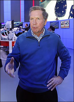 Ohio Gov. John Kasich speaks to the media while touring the Ford display at the North American International Auto Show in Detroit.