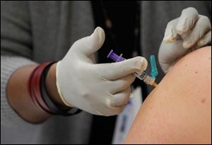A woman receives a flu shot. The flu season sometimes doesn’t peak until February.