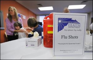 A youngster receives a shot during a vaccine clinic. The deaths of seven people in the region have spurred many to get a flu shot.