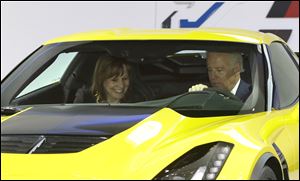 Vice President Biden and General Motors CEO Mary Barra sit in a Corvette Stingray during a tour of the auto show.