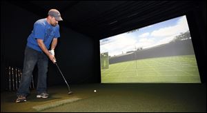 Steve Anglemyre of Holland plays a round of golf Tuesday at Fore Golfers, a 4,500-square-foot golf simulator in Holland.
