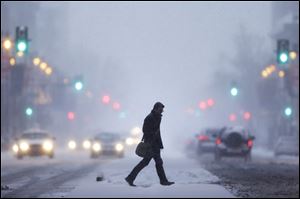 A man crosses Broad Street during a winter snowstorm Tuesday in Philadelphia.