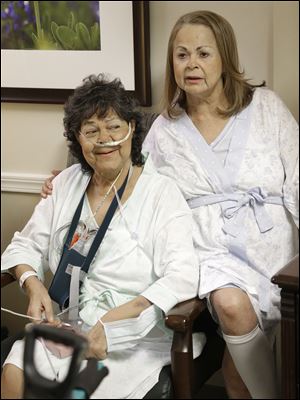 Irma Myers-Santana, left, and her sister Anna Williamson visit in Williamson's hospital room in Houston. Earlier this month the sisters ended up in the same operating room, each getting one lung from the same donor.