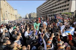 Egyptians shout anti-terrorism slogans as they demonstrate in front the site of a blast at the Egyptian police headquarters, at right, and the Islamic museum, at left, in downtown Cairo.