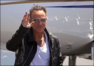 Bruce Springsteen, waves as he arrives at the airport in Cape Town, South Africa, today.