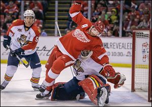 Detroit Red Wings right wing Daniel Cleary (71) falls over Florida Panthers goalie Tim Thomas (34) during the first period of an NHL hockey game in Detroit, Sunday, Jan. 26, 2014. (AP Photo/Carlos Osorio)