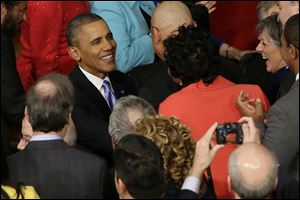 President Barack Obama is greeted as he arrives to give his State of the Union address on Capitol Hill in Washington.