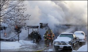 Firefighters battle a house fire at 905 Gould Street in Northwood on Tuesday. The house belongs to Bill Crosser, a Perrysburg Township firefighter, and his wife Pam, said Perrysburg Township dispatcher Morgan Donnell.