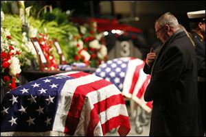Mayor D. Michael Collins prays before the coffin of James Dickman, during the Last Alarm funeral service at SeaGate Convention Centre for Toledo firefighters Stephen Machcinski and James Dickman, Thursday, Jan. 30, 2014.