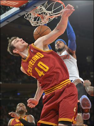 The Knicks' Carmelo Anthony dunks over the Cavaliers' Tyler Zeller during the first quarter Thursday night in New York. Anthony scored 18 in the first quarter alone.