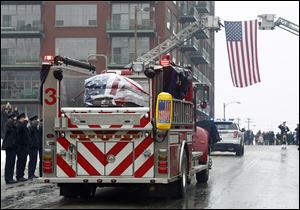 Toledo Firefighters salute as the casket of Toledo Firefighter Stephen Machcinski passes by Station 5 in Downtown Toledo.