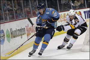 Toledo's Travis Novak (12) brings the puck around under pressure form Cincinnati's Dan Eves (16) during the first period .