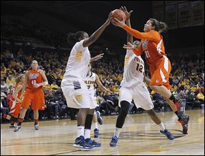 Bowling Green’s Erica Donovan has her shot blocked by Toledo's Brianna Jones, left, while Janice Monakana (12) defends during the second half on Sunday at Savage Arena.