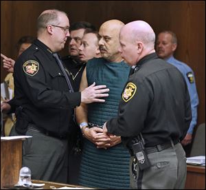 Sheriff’s deputies try to keep Ray Abou-Arab, who is dressed in a suicide smock, from talking to people in the courtroom following his arraignment.