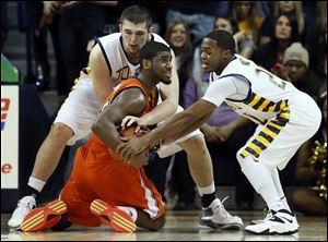 University of Toledo center Nathan Boothe (53) and guard Julius Brown (20) battle Bowling Green State University guard Jehvon Clarke (20) for a loose ball.