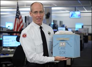 Lt. Matthew Hertzfeld holds the Smile Basket, which is sent around the country from fire dispatchers who have dealt with line-of-duty deaths. The basket is filled with goodies and messages of support. 