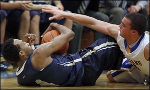 St. John's Jesuit's Anthony Glover, Jr. (4) battles against Findlay's Braden Miller (4) for a loose ball.