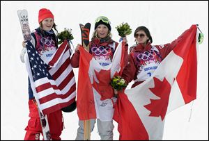 Canada's Dara Howell, center, celebrates on the podium with silver medalist Devin Logan of the United States, left, and Kim Lamarre, right,  also of Canada, after Howell took the gold medal in the women's freestyle skiing slopestyle final.