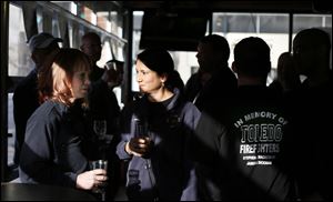 Toledo Firefighters Sharyl Close, left, and Debbie Phillips have a drink and talk prior to one-day fundraiser.