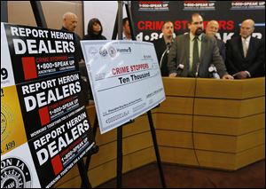 Joseph Costello, chief assistant prosecuting attorney for Monroe County, speaks at a news conference at the Monroe County Courthouse. In the forefront is the ‘check’ for $10,000 donated to the Michigan Crimestoppers program by three unions to  combat the heroin and opiate epidemic.