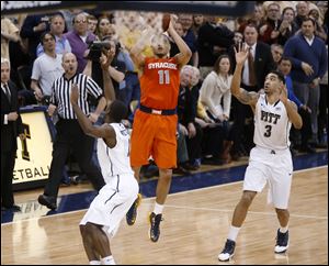 Syracuse's Tyler Ennis shoots a 3-pointer between Pittsburgh's Cameron Wright (3) and Josh Newkirk, left, in the final second Wednesday in Pittsburgh. The shot went in and Syracuse won 58-56.