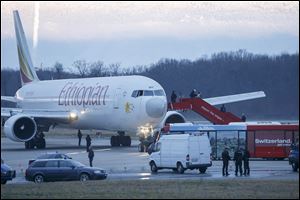 Police stand around the aircraft after passengers were evacuated from a hijacked Ethiopian Airlines Plane on the airport in Geneva, Switzerland today.