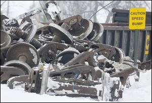 The wheels of railroad cars are piled up as workers clear a train derailment in Tontogony, Ohio. Debris near the track could remain for months.