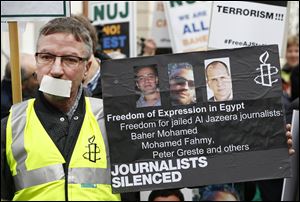 Journalists hold up placards as they demonstrate across the street from Egypt's embassy in central London, Wednesday. The protest organized by the National Union of Journalists called for the protection of journalists in Egypt, where six have been killed and many more injured covering events.