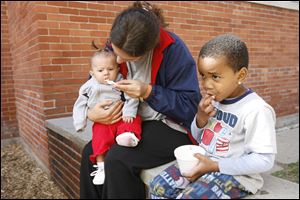 Deedee Pasco and her daughter Mylisia enjoy a bit of ice cream with Thomas Claybourne, at a La Posada Family Emergency Center ice cream social for current and former residents.