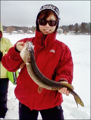 Bernadette Harkness, a chemistry professor at Michigan’s Delta College, near Bay City, holds a northern pike she caught last winter.