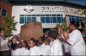 In 2003, Peter Ujvagi, left, then a state representative, was joined by schoolchildren as an Ohio Historical Marker was unveiled to honor Moses Fleetwood Walker in front of the Toledo Mud Hens’ stadium, Fifth Third Field.