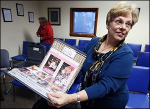 Darlene Limmer, head of the Walbridge centennial commission, with a centennial scrapbook that was presented to a representative of the Walbridge Library following a council meeting Wednesday in Walbridge.