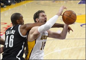 Brooklyn Nets center Jason Collins, left, fouls Los Angeles Lakers center Pau Gasol on Sunday in Los Angeles. The Nets won 108-102. Collins was signed to a 10-day contract Sunday, nearly 10 months after his announcement on April 29 in Sports Illustrated. He played 10 scoreless minutes with two rebounds and five fouls.