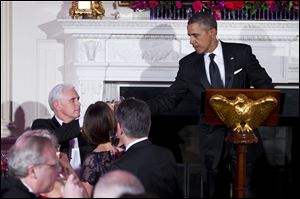 President Obama, right, and Indiana Gov. Mike Pence, toast during a dinner for the National Governors Association in the State Dining room of the White House Sunday.