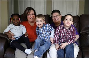 April DeBoer, second from left, sits with her adopted daughter Ryanne, left, 3, and Jayne Rowse, fourth from left, and her adopted sons Jacob, 3, middle, and Nolan, 4, right, at their home in Hazel Park, Mich., in March, 2013.