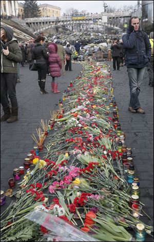 People lay down flowers on one of the streets leading to Independence Square, Kiev,  the epicenter of the country's recent unrest, on a mourning day,  Monday.