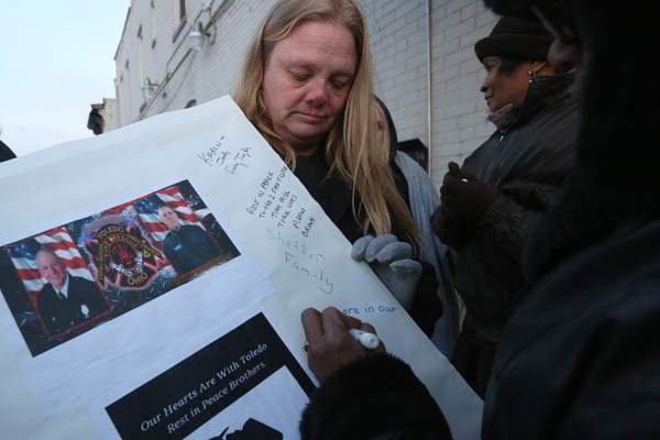 Tracy-Baker-center-holds-a-poster-to-for-a-lo