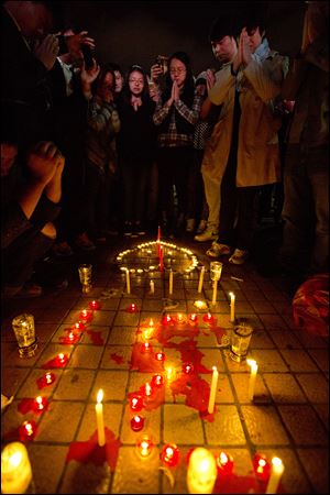 People light up candles and pray for the victims on a square outside the Kunming Railway Station where more than 10 assailants slashed scores of people with knives the night before in Kunming, in western China's Yunnan province, Sunday.