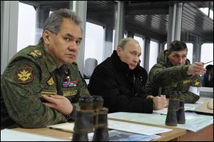 Russian President Vladimir Putin, center, Defense Minister Sergei Shoigu, left, and Chief of Staff Training Directorate Gen. Ivan Buvaltsev, watch an exercise near St. Petersburg, Russia. Officials there say they are protecting Russians in Crimea.