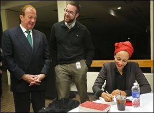 Author Zadie Smith jokes with John Szuch, left, and Steve Szuch as she signs books at the 2014 Authors! Authors! series at Stranahan Theater in South Toledo.