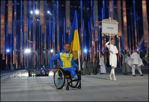 Biathlete Mykhaylo Tkachenko, representing Ukraine, enters the arena during the opening ceremony of the 2014 Winter Paralympics.