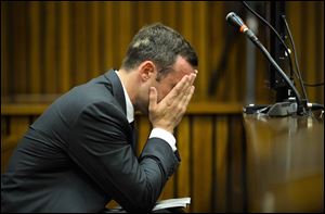 Oscar Pistorius, cradles his head in his hands in court on the fifth day of his trial at the high court in Pretoria, South Africa. The Olympian is charged with murder for the shooting death of his girlfriend,  Reeva Steenkamp, on Valentines Day in 2013.