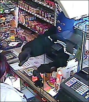 An image from a store security camera shows the would-be robber at the Stop & Go, 3645 Upton Ave., pointing a gun at the clerk during a holdup there Thursday morning.