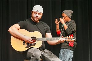 Musician Chris Shutters is filmed by Toledo School for the Arts seventh grader Morgan Harrison during Shorties U at North-view High School in Sylvania.
